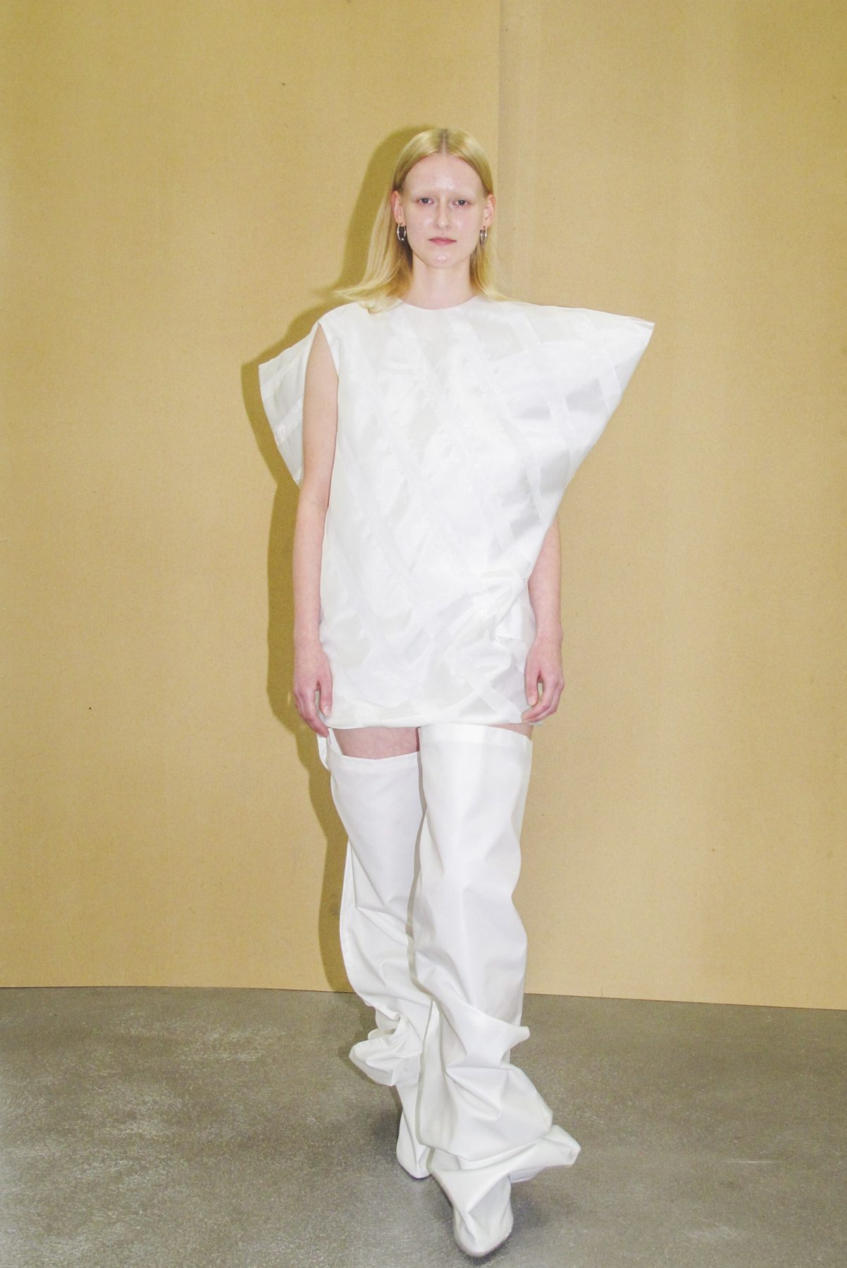 Photo of model wearing white vortex dress and long white boots