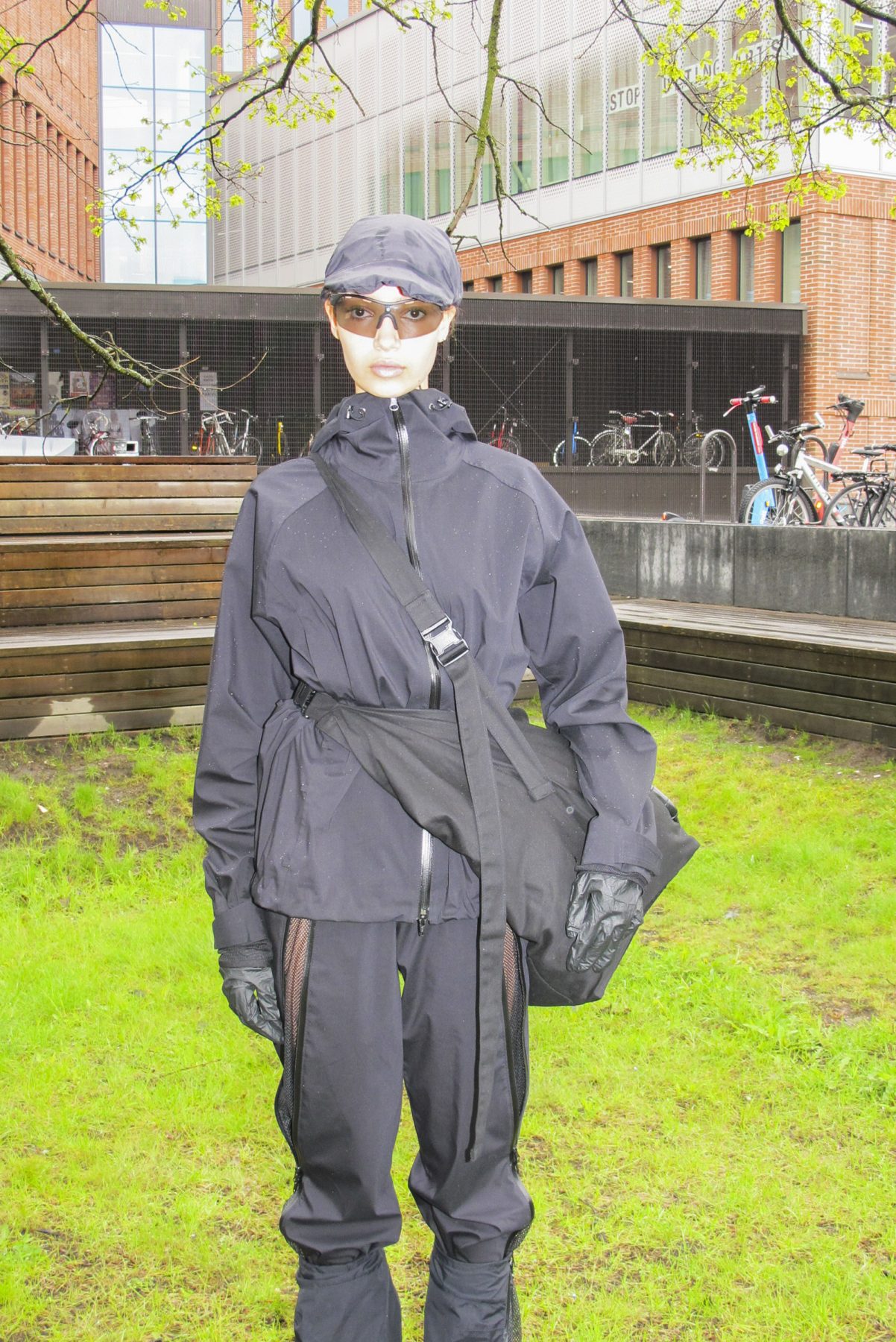 Model is wearing a black windproof jacket with cross-body fanny pack