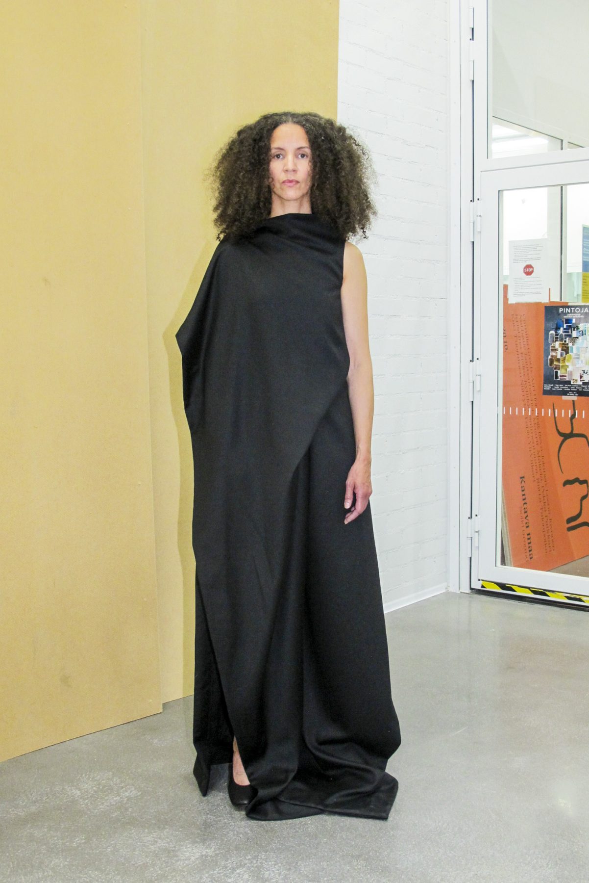 Photo of model wearing long black draped dress