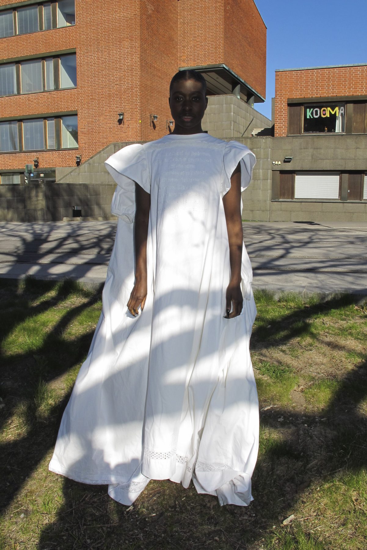 Model is wearing a long white dress