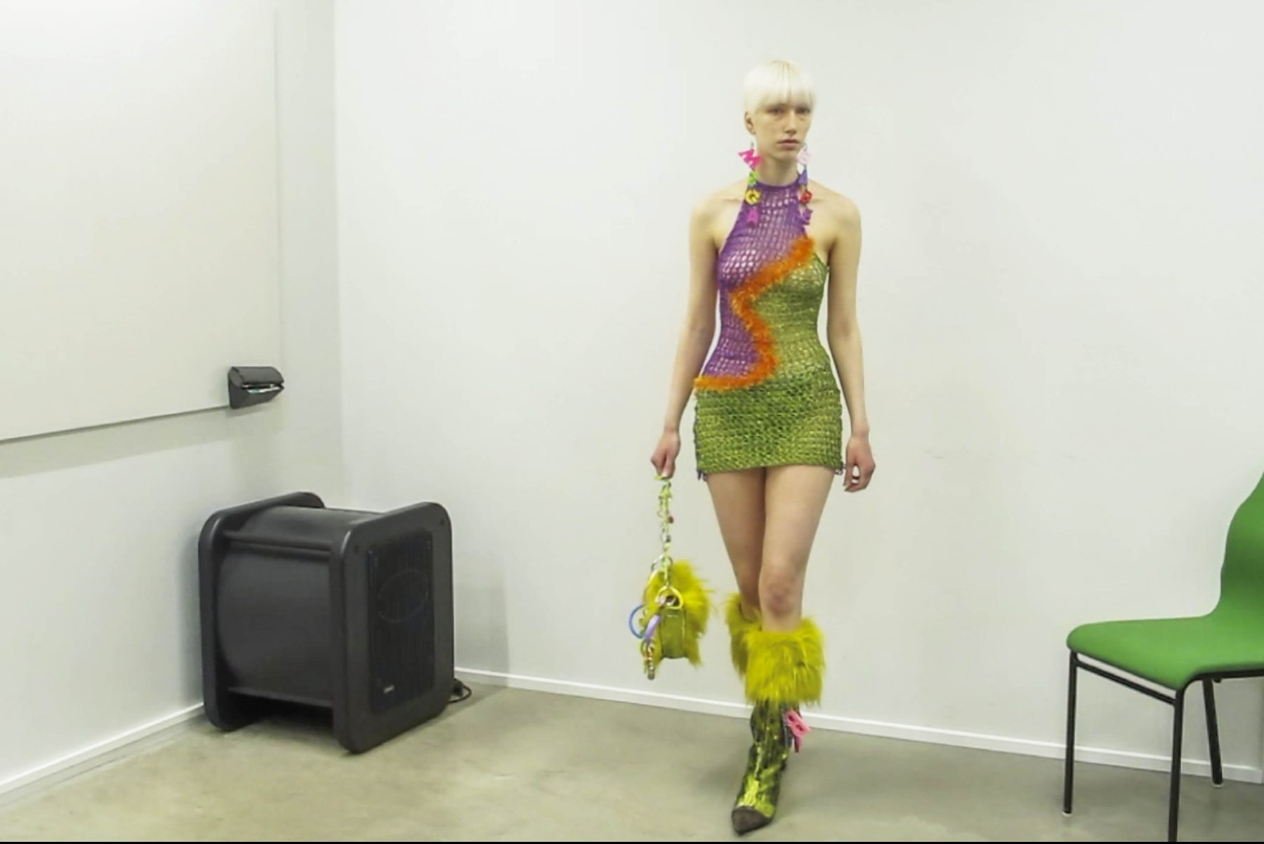 Photo of model walking wearing short colorful crochet dress and megababe earrings