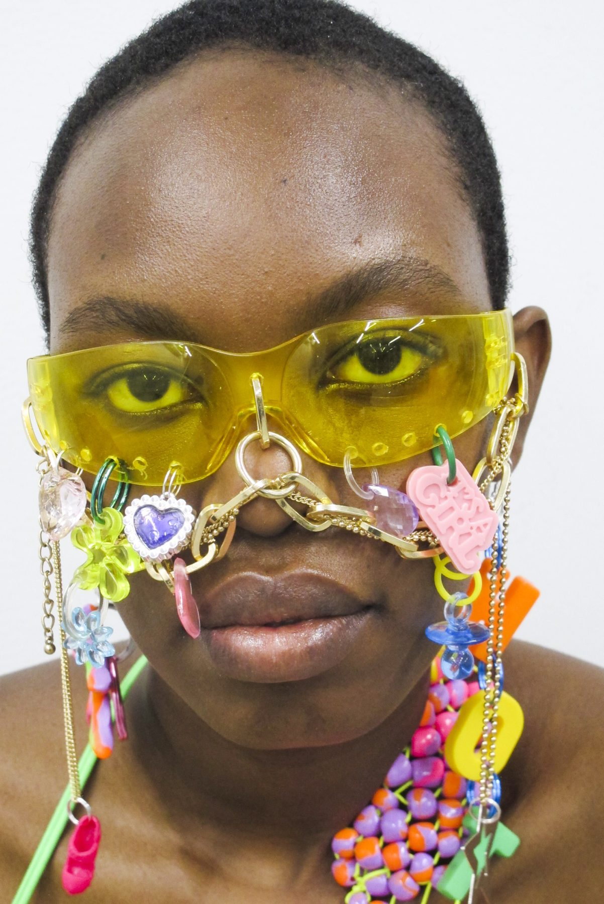 Close-up photo of model wearing decorated eyeglasses with chains and figures