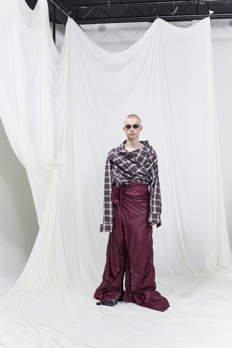 Model is wearing an oversized brown checked shirt and burgundy tracksuit pants