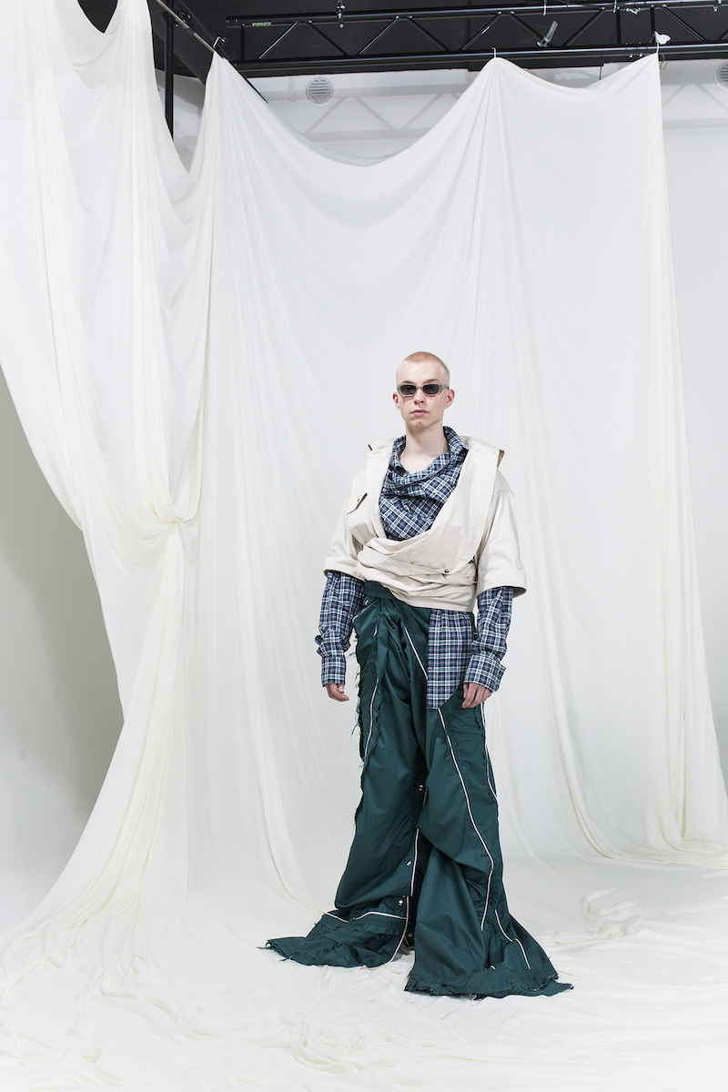 Model is wearing oversized shirt and tracksuit pants in green, sunglasses