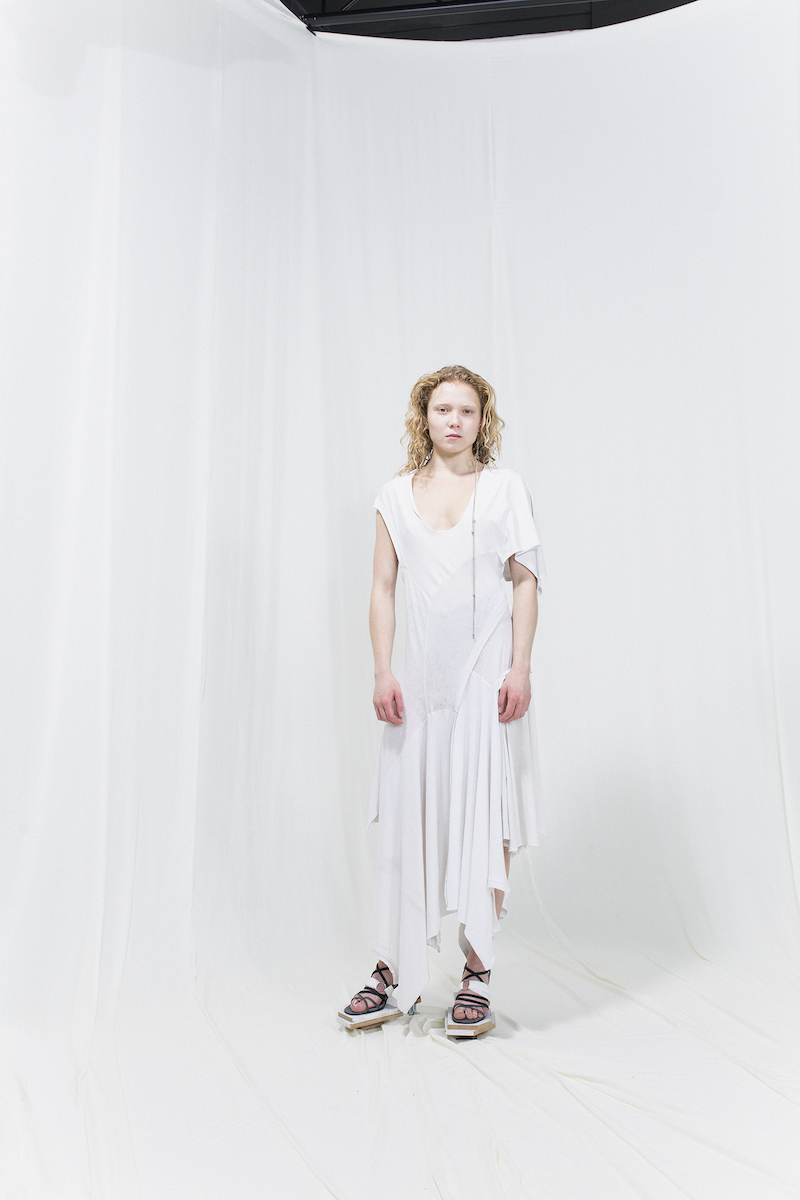 Model is wearing a white asymmetric dress