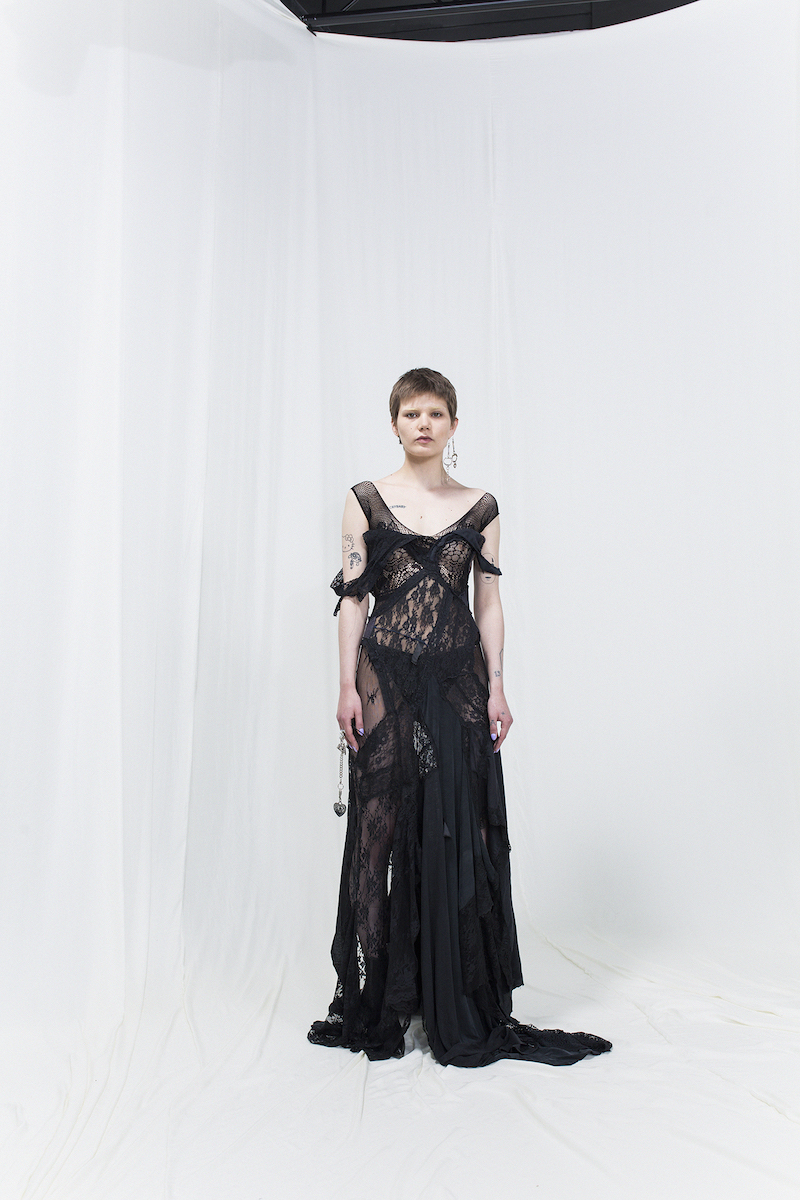 Model is wearing a black asymmetric lace gown
