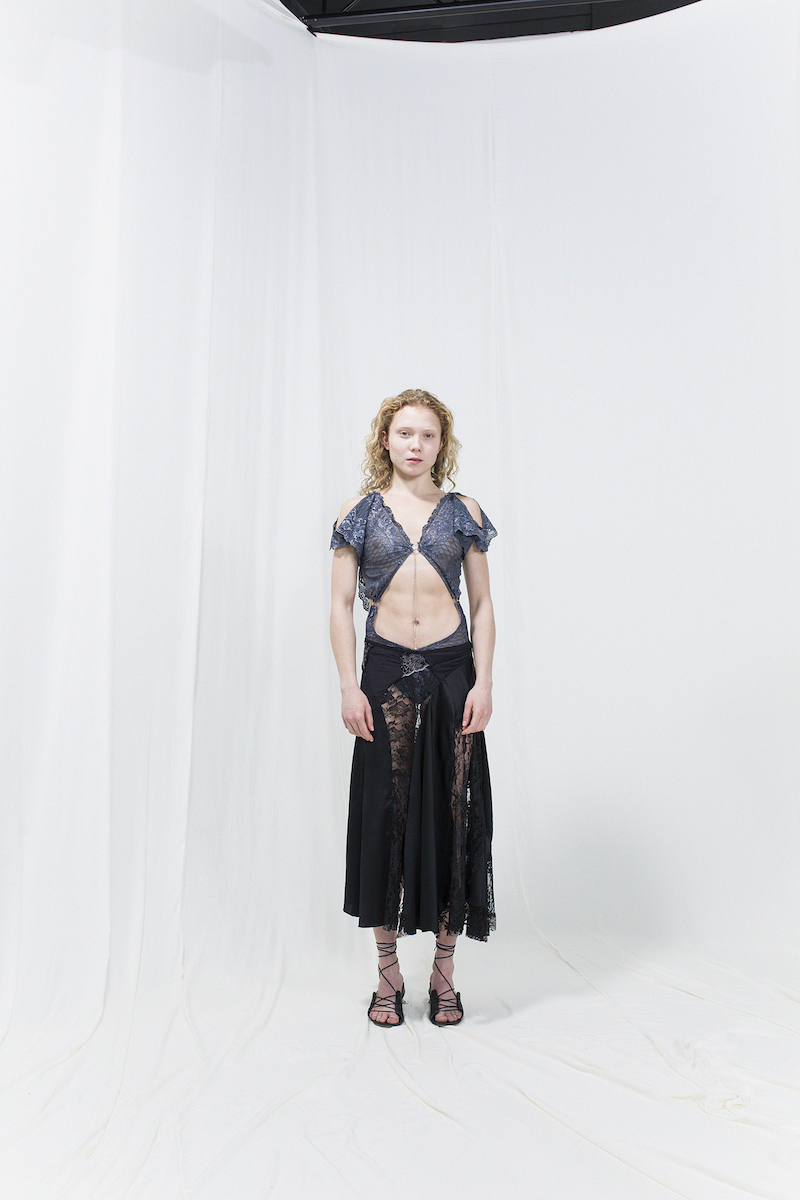 Model is wearing a blue see through lace top and back lace-panelled skirt