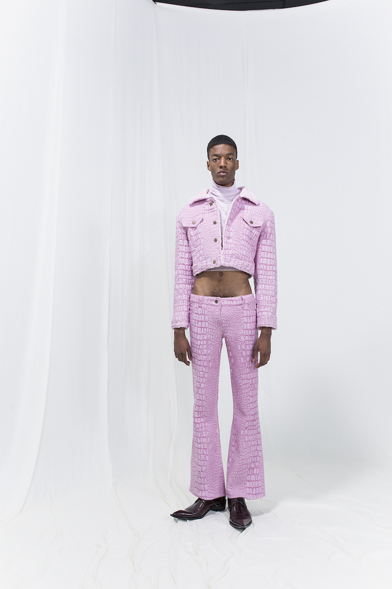 Model is wearing a pale pink cropped turtleneck, short crocodile-imitation jacquard-woven jacket with matching trousers