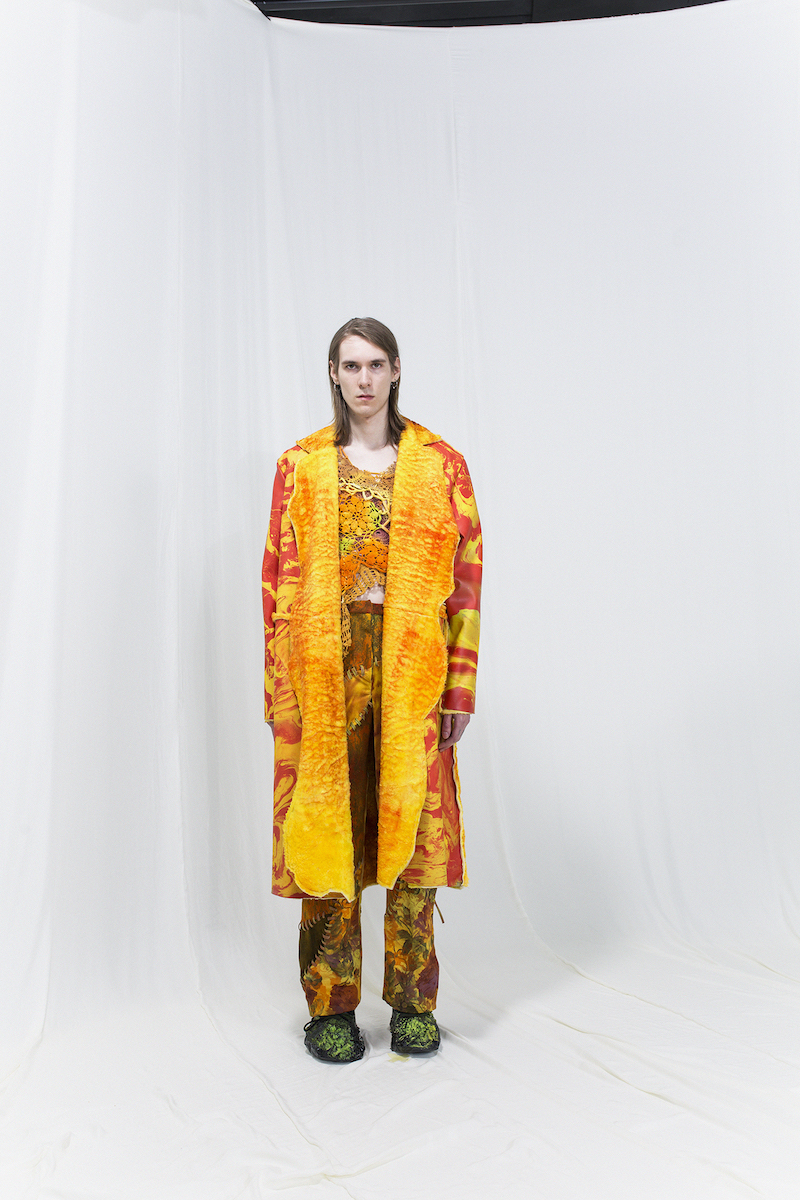 Model wearing a red & yellow marbled shearling coat with crochet top underneath, matching trousers