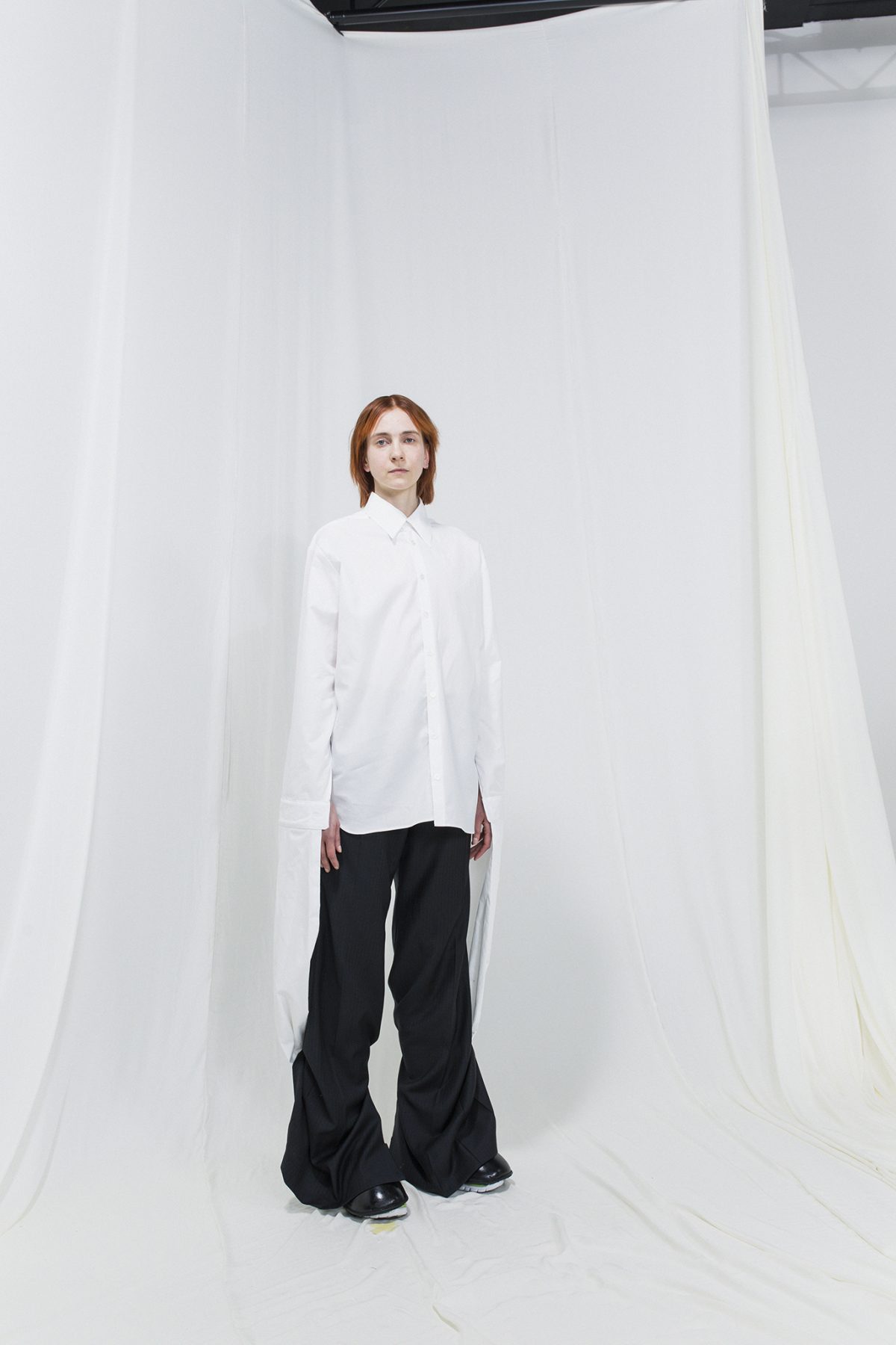 Model wearing an oversized white shirt with oversized black trousers